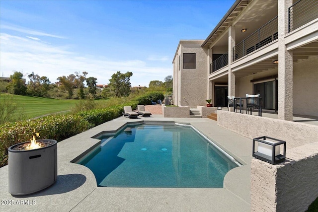 view of swimming pool featuring an outdoor fire pit and a patio area