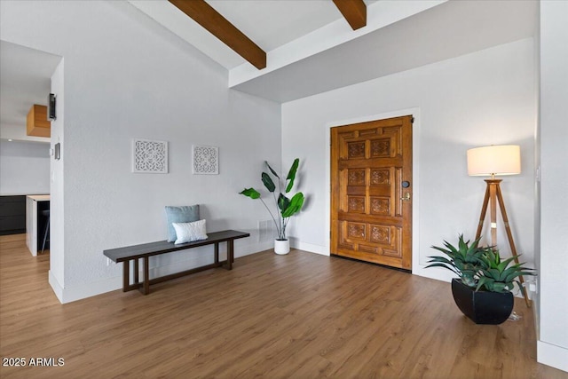 entrance foyer featuring lofted ceiling with beams and hardwood / wood-style flooring