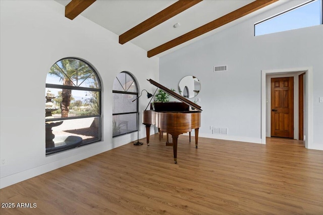 miscellaneous room featuring beamed ceiling, light hardwood / wood-style floors, and high vaulted ceiling