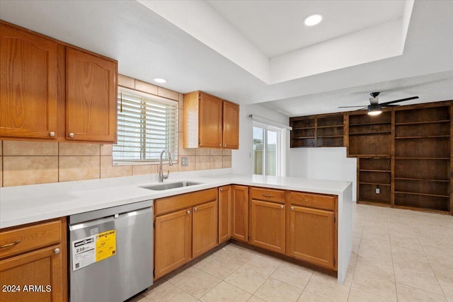 kitchen with decorative backsplash, kitchen peninsula, sink, light tile patterned floors, and stainless steel dishwasher