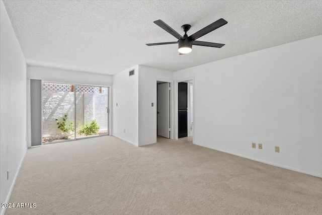 carpeted spare room featuring a textured ceiling and ceiling fan