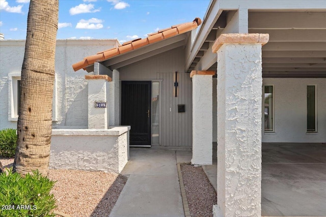 view of exterior entry with a patio area