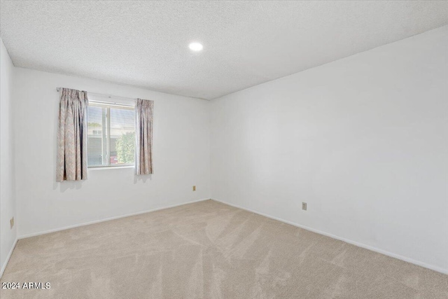 carpeted spare room featuring a textured ceiling