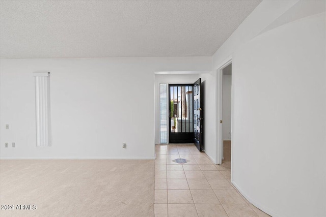 tiled entryway featuring a textured ceiling