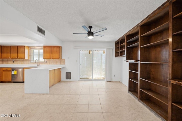 kitchen featuring tasteful backsplash, light tile patterned floors, ceiling fan, a textured ceiling, and sink