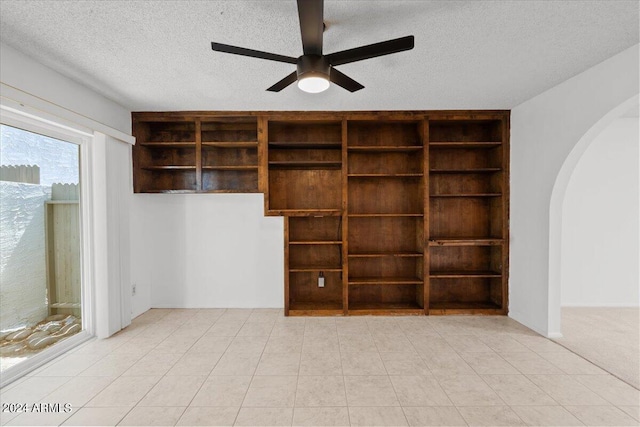 unfurnished room with ceiling fan and a textured ceiling