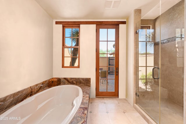 bathroom with a garden tub, french doors, and a shower stall