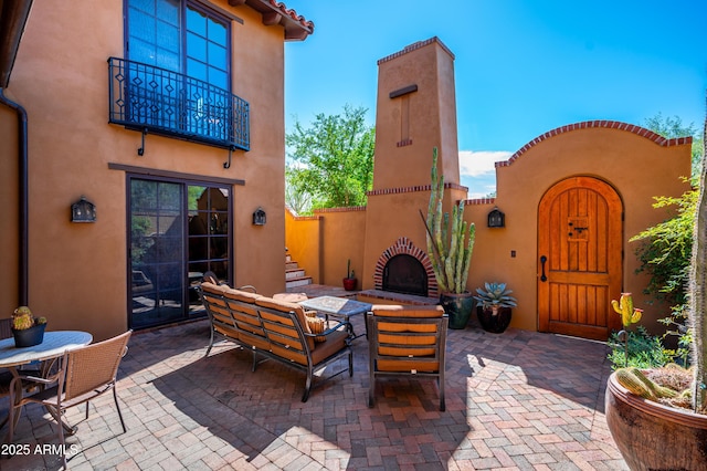 view of patio with a balcony and outdoor dining area