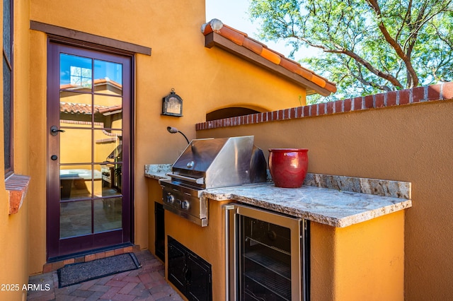 view of patio with wine cooler, an outdoor kitchen, and area for grilling