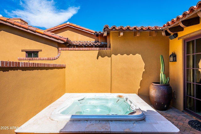 view of patio / terrace featuring an outdoor hot tub