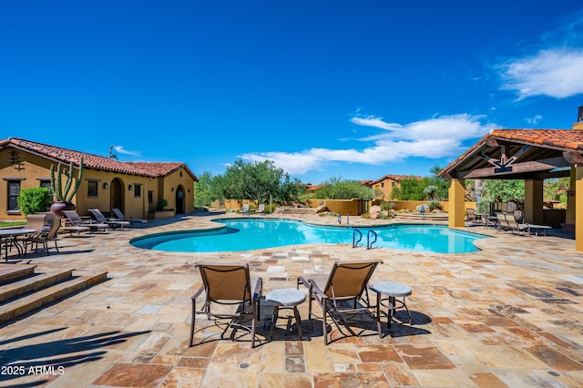 pool with a patio area, fence, and a gazebo