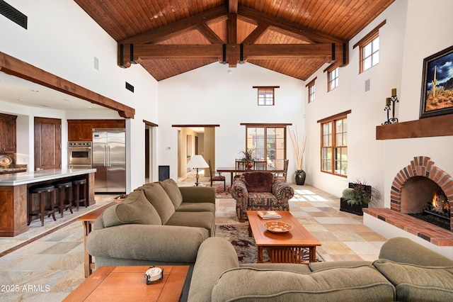 living room with plenty of natural light, wood ceiling, visible vents, and a fireplace