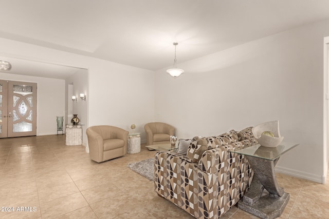 living area featuring french doors and light tile patterned floors