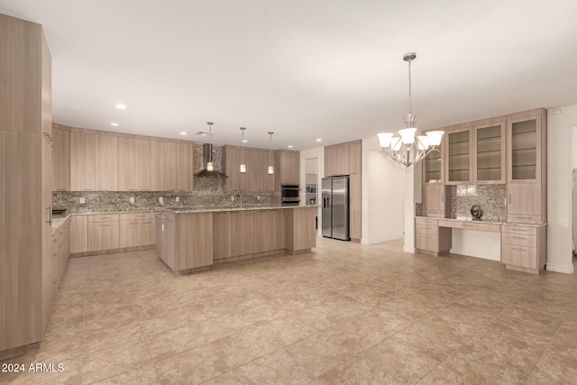 kitchen with light stone countertops, light brown cabinets, wall chimney exhaust hood, a large island, and stainless steel fridge