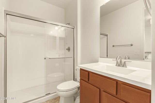 bathroom featuring toilet, an enclosed shower, and vanity