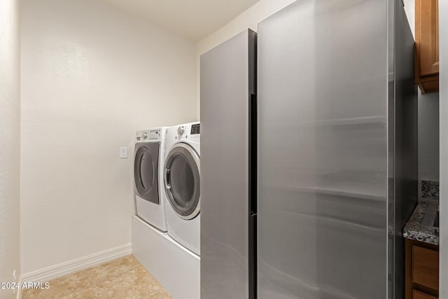 laundry room featuring washer and clothes dryer and light tile patterned flooring