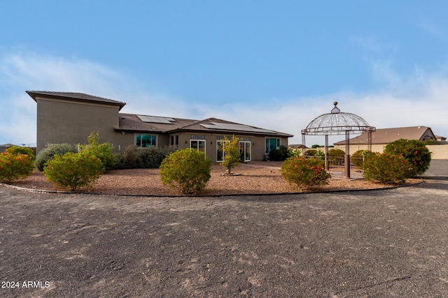 view of front of home featuring solar panels and a gazebo