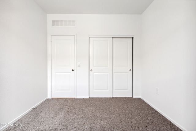 unfurnished bedroom with a closet and carpet flooring