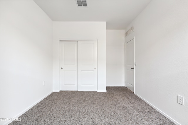 unfurnished bedroom with a closet and carpet floors