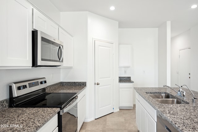 kitchen with white cabinetry, appliances with stainless steel finishes, sink, and stone countertops