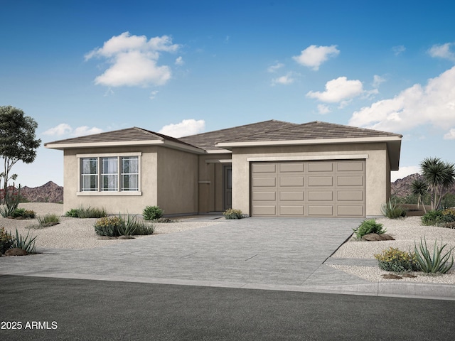 view of front of house featuring stucco siding, decorative driveway, and a garage