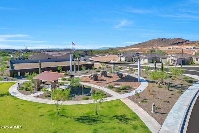 view of property's community with a mountain view, a residential view, and a lawn