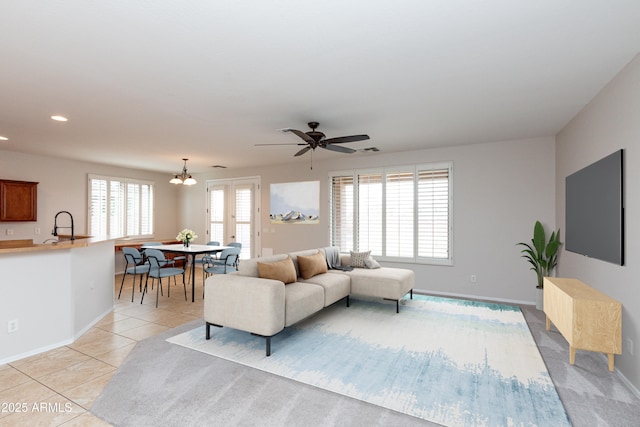 living room with recessed lighting, baseboards, light tile patterned flooring, and ceiling fan with notable chandelier