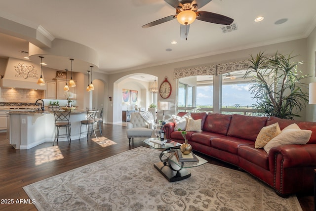 1617 E Copper Holw, Queen Creek, AZ 85140 - living area featuring arched walkways, a ceiling fan, dark wood-style floors, crown molding, and recessed lighting