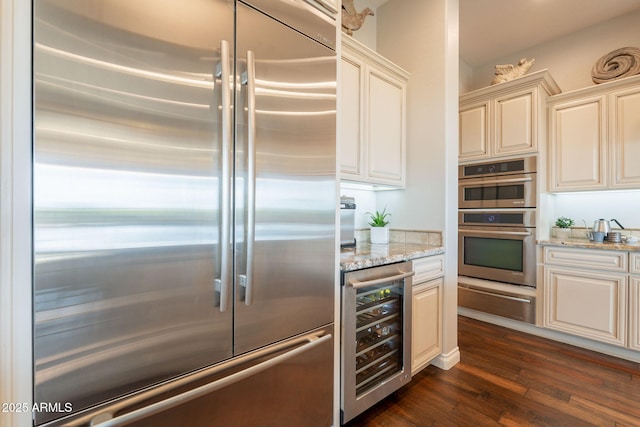 1617 E Copper Holw, Queen Creek, AZ 85140 - kitchen with appliances with stainless steel finishes, beverage cooler, a warming drawer, dark wood finished floors, and light stone countertops
