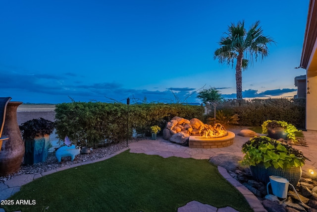 1617 E Copper Holw, Queen Creek, AZ 85140 - yard at dusk with an outdoor fire pit and a lawn