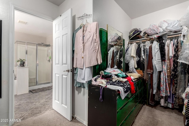 spacious closet featuring light carpet, visible vents, and light tile patterned flooring