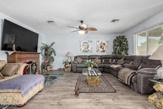 living area featuring a ceiling fan, visible vents, and light wood-style floors