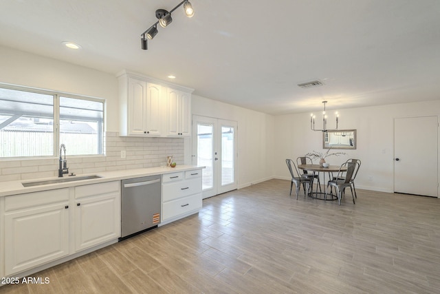 kitchen featuring visible vents, decorative backsplash, french doors, stainless steel dishwasher, and a sink