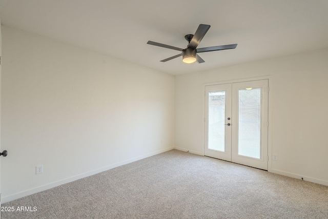 carpeted spare room with french doors, ceiling fan, and baseboards