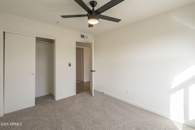 unfurnished bedroom with light carpet, a closet, visible vents, and baseboards