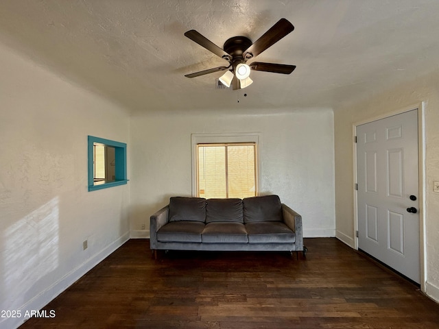 living room with ceiling fan, dark hardwood / wood-style flooring, and a textured ceiling