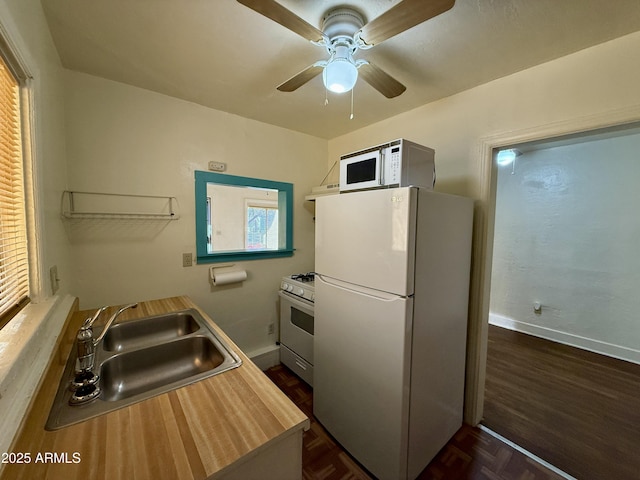 kitchen with ceiling fan, sink, dark parquet floors, white appliances, and exhaust hood