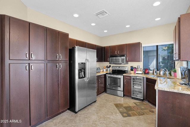 kitchen featuring wine cooler, light tile patterned flooring, sink, stainless steel appliances, and light stone countertops