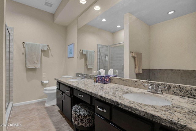 bathroom featuring a shower with door, vanity, tile patterned floors, and toilet