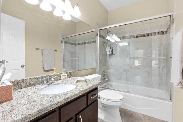 full bathroom featuring vanity, bath / shower combo with glass door, tile patterned floors, and toilet