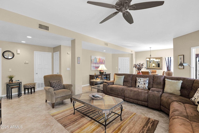 living room featuring ceiling fan with notable chandelier and light tile patterned floors