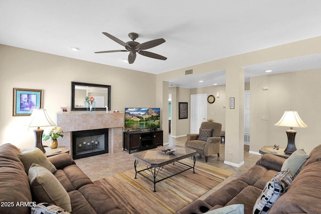 living room with ceiling fan and a fireplace