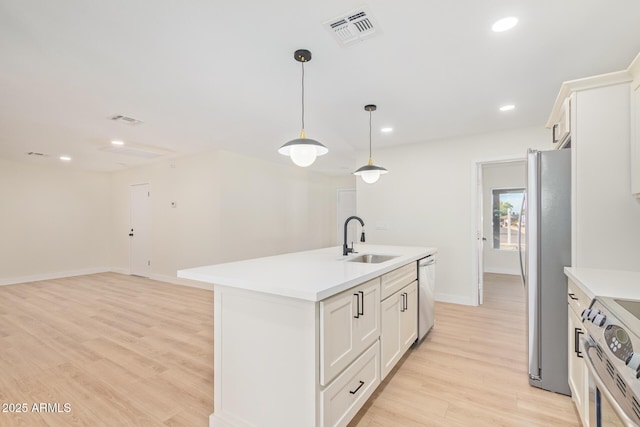 kitchen with light wood-style flooring, appliances with stainless steel finishes, visible vents, and a sink