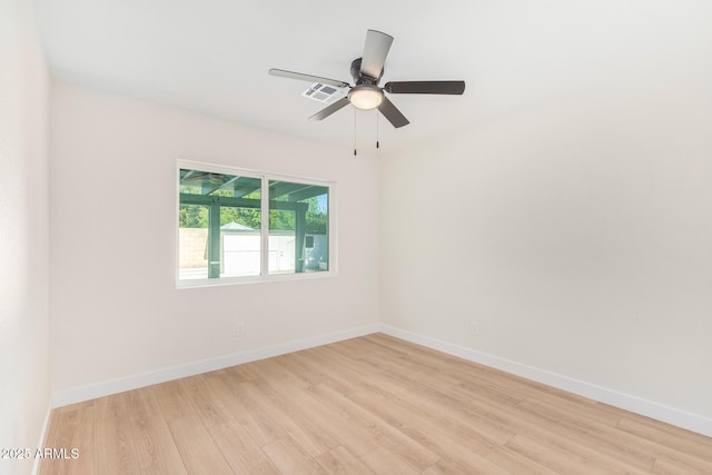 spare room with baseboards, a ceiling fan, visible vents, and light wood-style floors