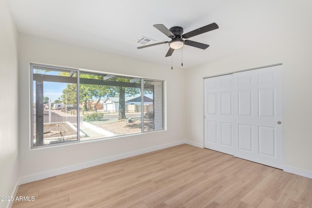 unfurnished bedroom featuring light wood finished floors, a closet, visible vents, and baseboards