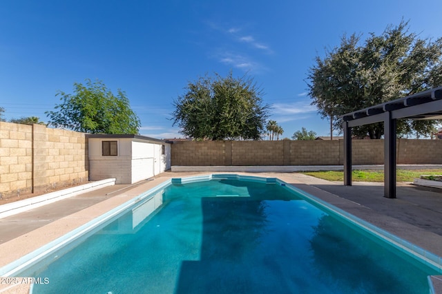 view of swimming pool featuring a fenced backyard, an outbuilding, a fenced in pool, and a patio