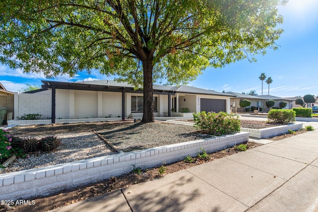 view of front of property featuring driveway, an attached garage, and brick siding