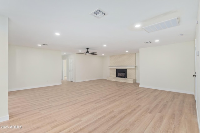 unfurnished living room with visible vents, ceiling fan, light wood-type flooring, a brick fireplace, and recessed lighting