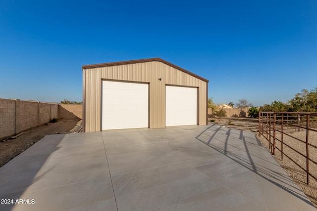 detached garage featuring fence