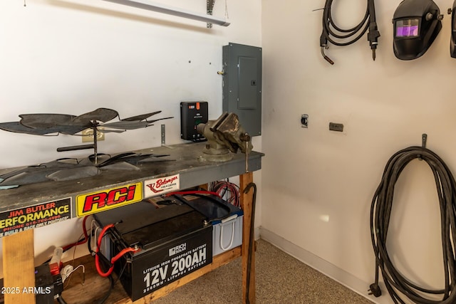 garage featuring electric panel and baseboards